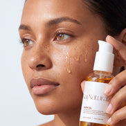 Model applying Glow Oil to her cheek
