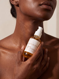 Glow Oil held at the collarbone