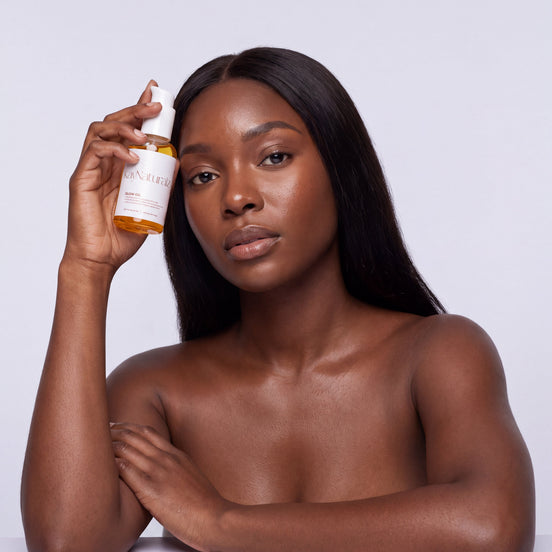 Model holding the Glow Oil beside her face