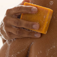 Organic Turmeric Soap Bar in use on the shoulder