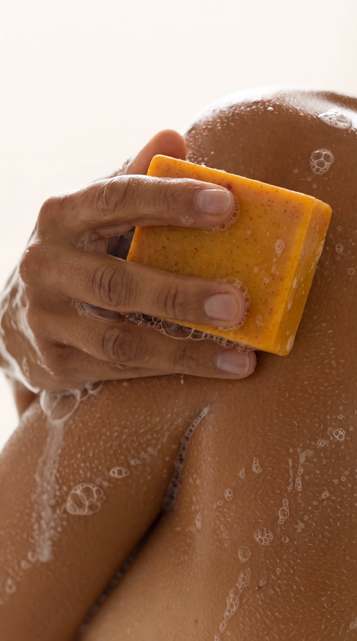 Organic Turmeric Soap Bar in use on the shoulder